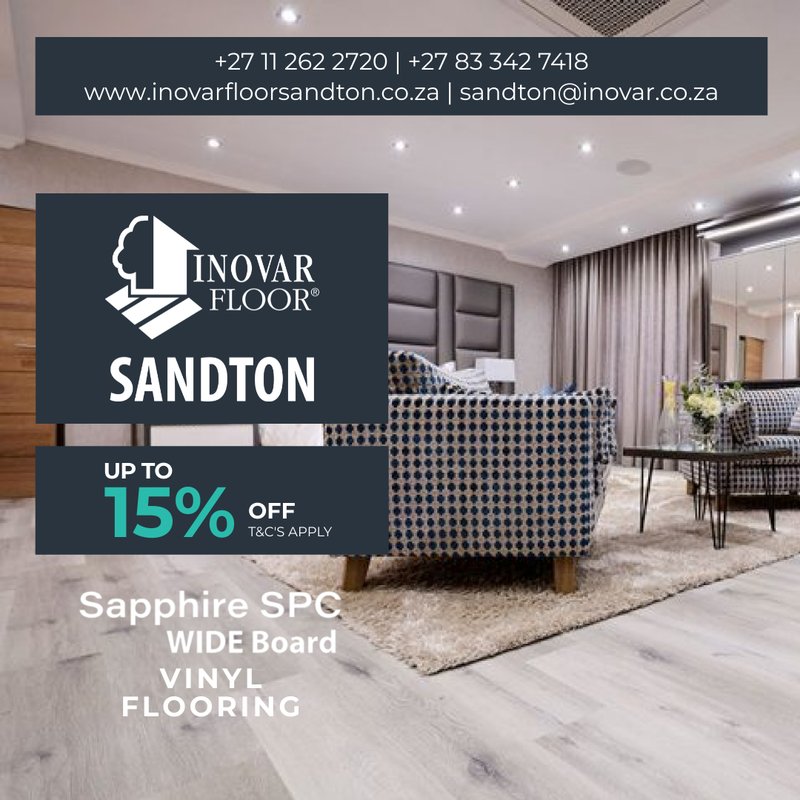 Large-scale bedroom or lounge area featuring Sapphire SPC wide board vinyl flooring in a cool grey wood-look finish.