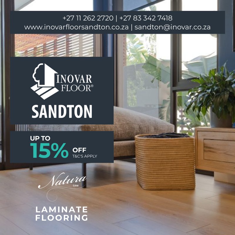 Bright living room with floor-to-ceiling windows highlighting the smooth grain of Natura Line laminate flooring.