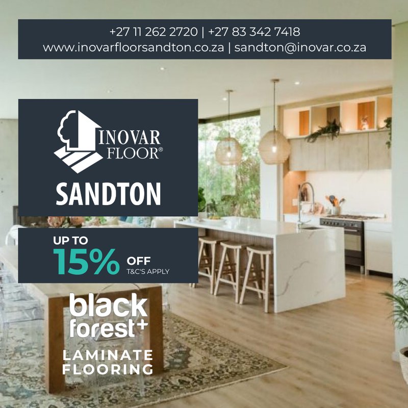 Interior view of a modern open-plan kitchen and dining area featuring light-toned Black Forest+ laminate flooring with a 15% off promotional overlay.